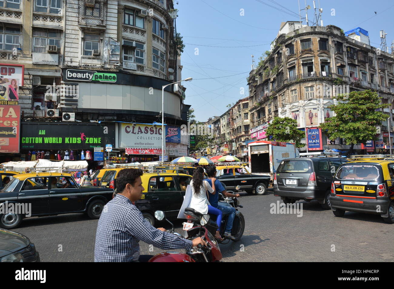 Mumbai, India - October 19, 2015 - Many people and rickshaws move slowly in the very crowded streets and traffic in Mumbai with tuk tuk and taxis Stock Photo