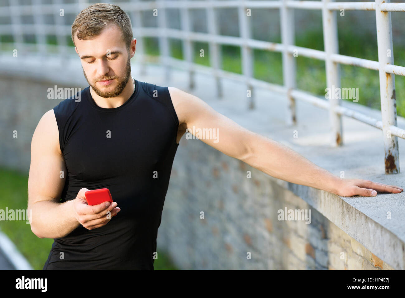 Man standing with red mobile phone Stock Photo