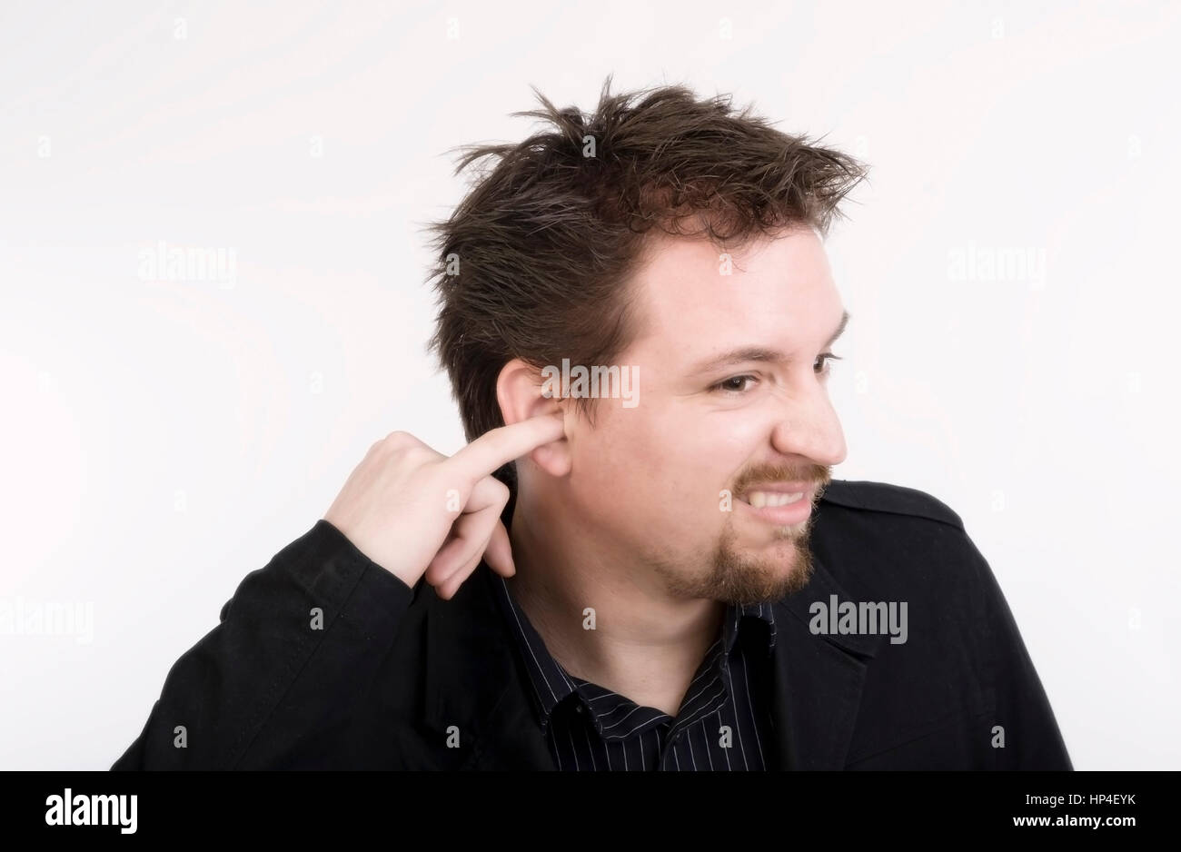 Model released , Junger Mann kratzt sich im Ohr - young man scratches in ear Stock Photo
