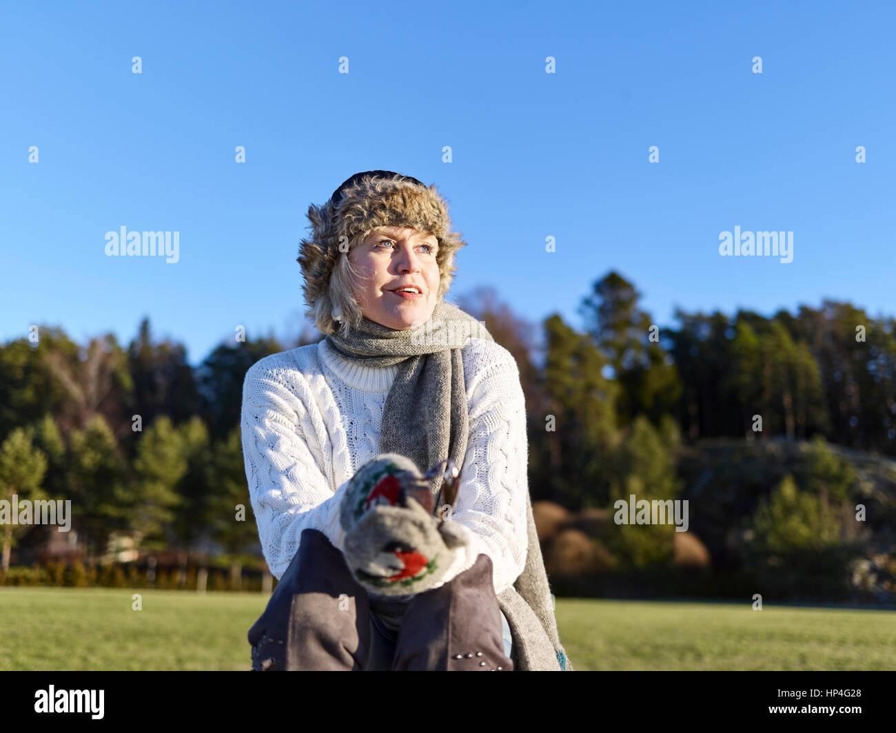 Happy mature woman on the park and she looks the other way, sunny winter day Stock Photo