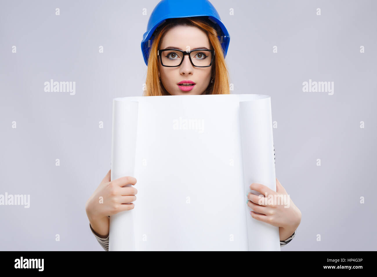 Girl in blue helmet holding sheet of paper Stock Photo - Alamy