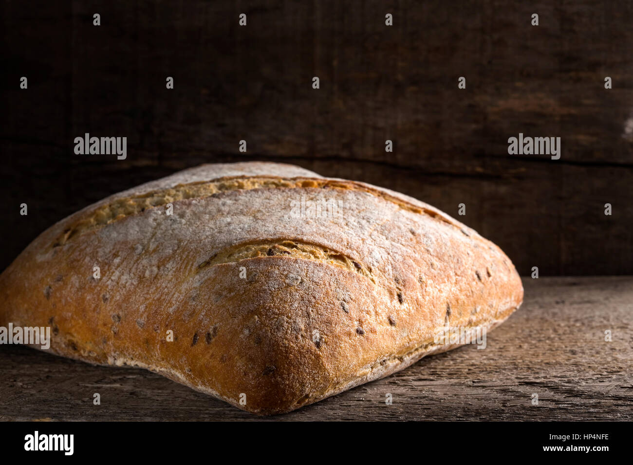 One baked seeds bread over old rustic wooden background Stock Photo