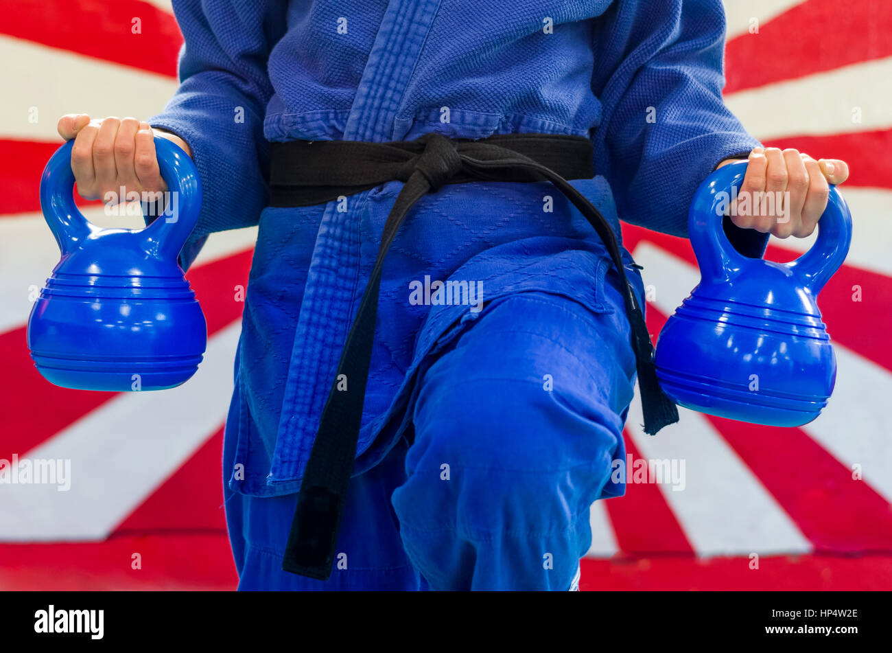 Close Up of Woman in Blue Judo Gi, and Black Belt, which is Train with