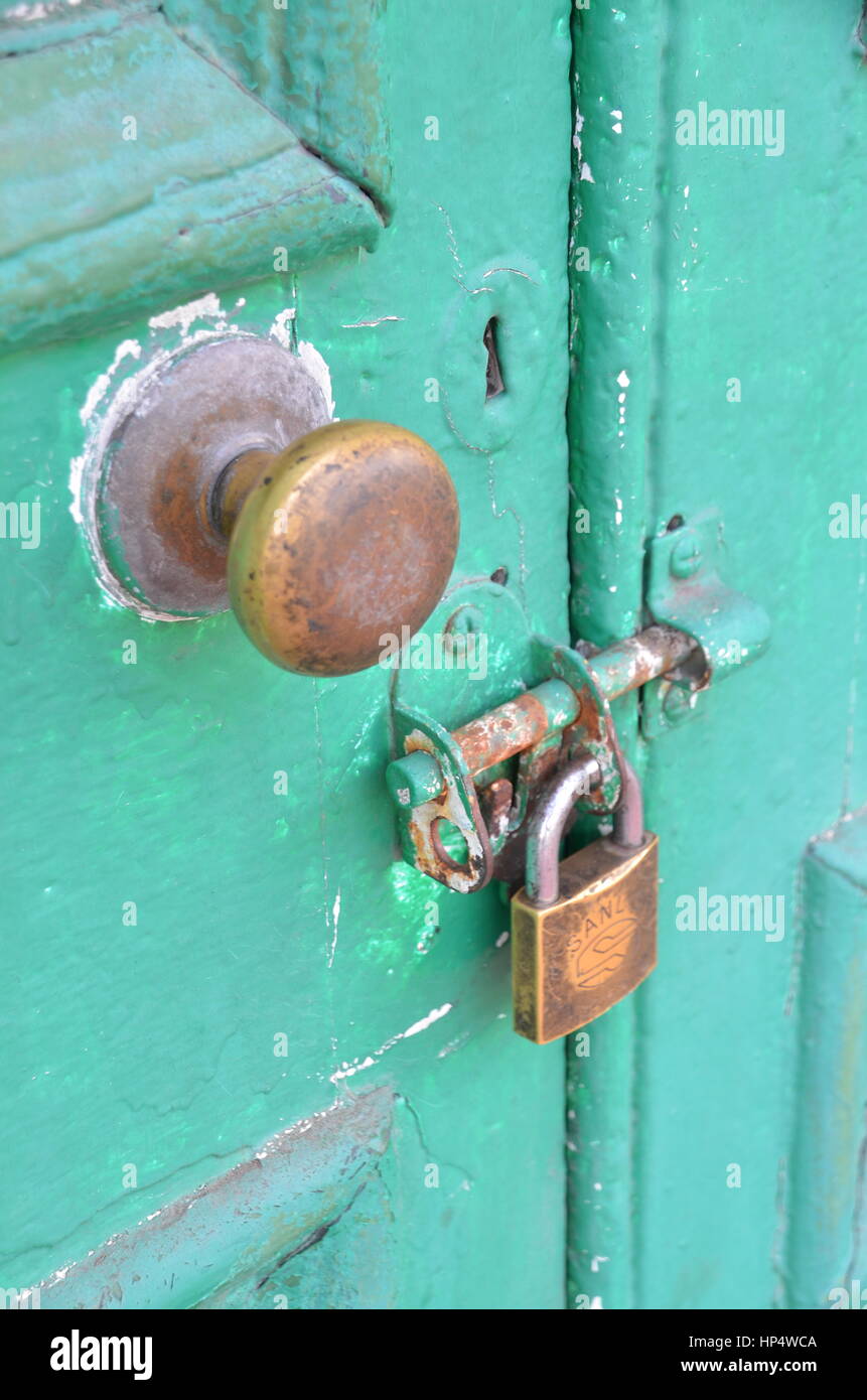 Old secure padlocked green door Stock Photo