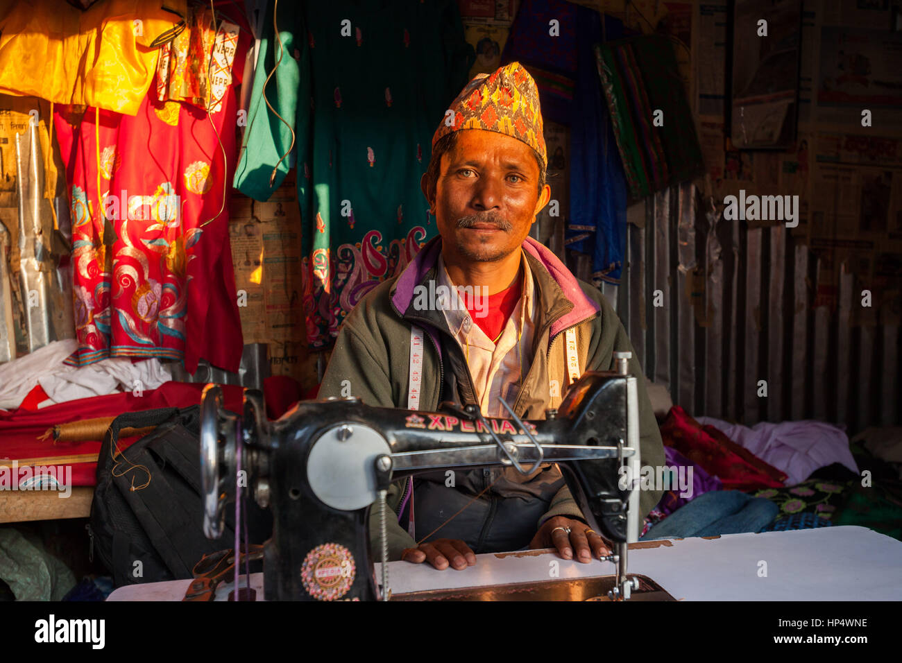Nepali tailor sitting at a traditional treadle sewing machine Stock