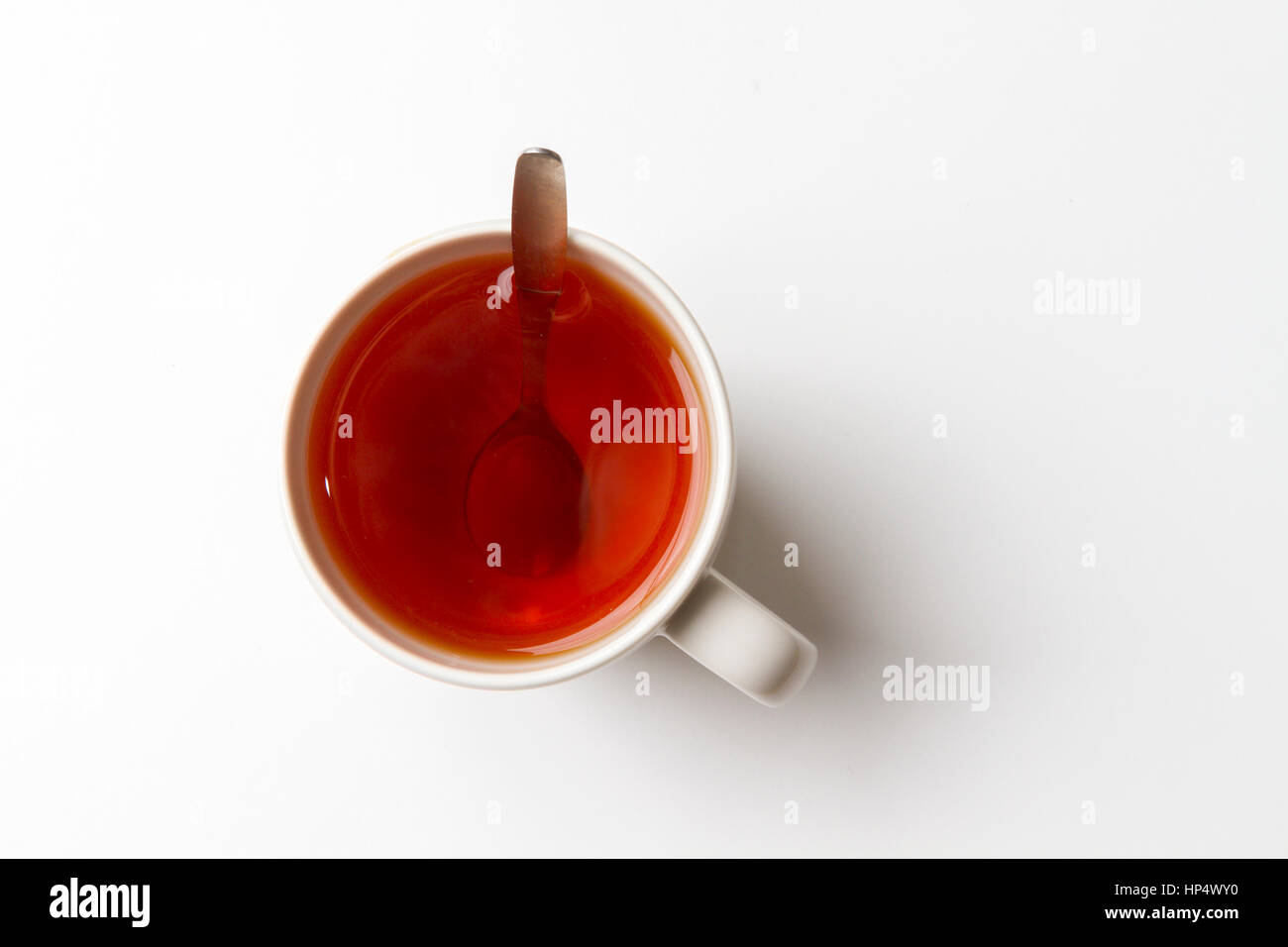 a cup of tea with spoon on a white background. Landscape mode, isolated, top view. Stock Photo