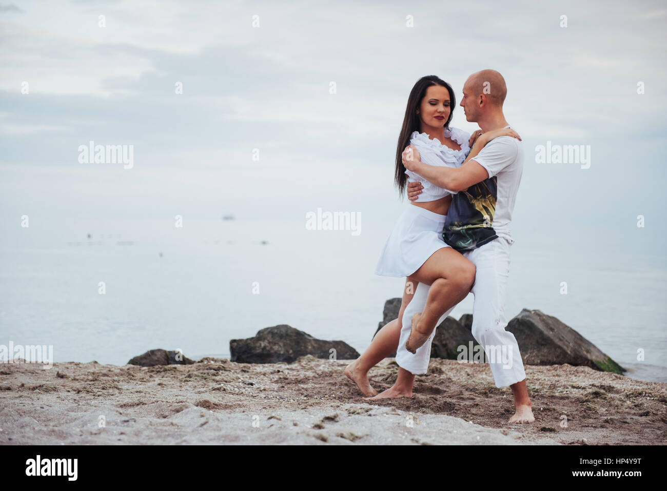 beautiful couple dancing on the beach at the background Stock Photo - Alamy