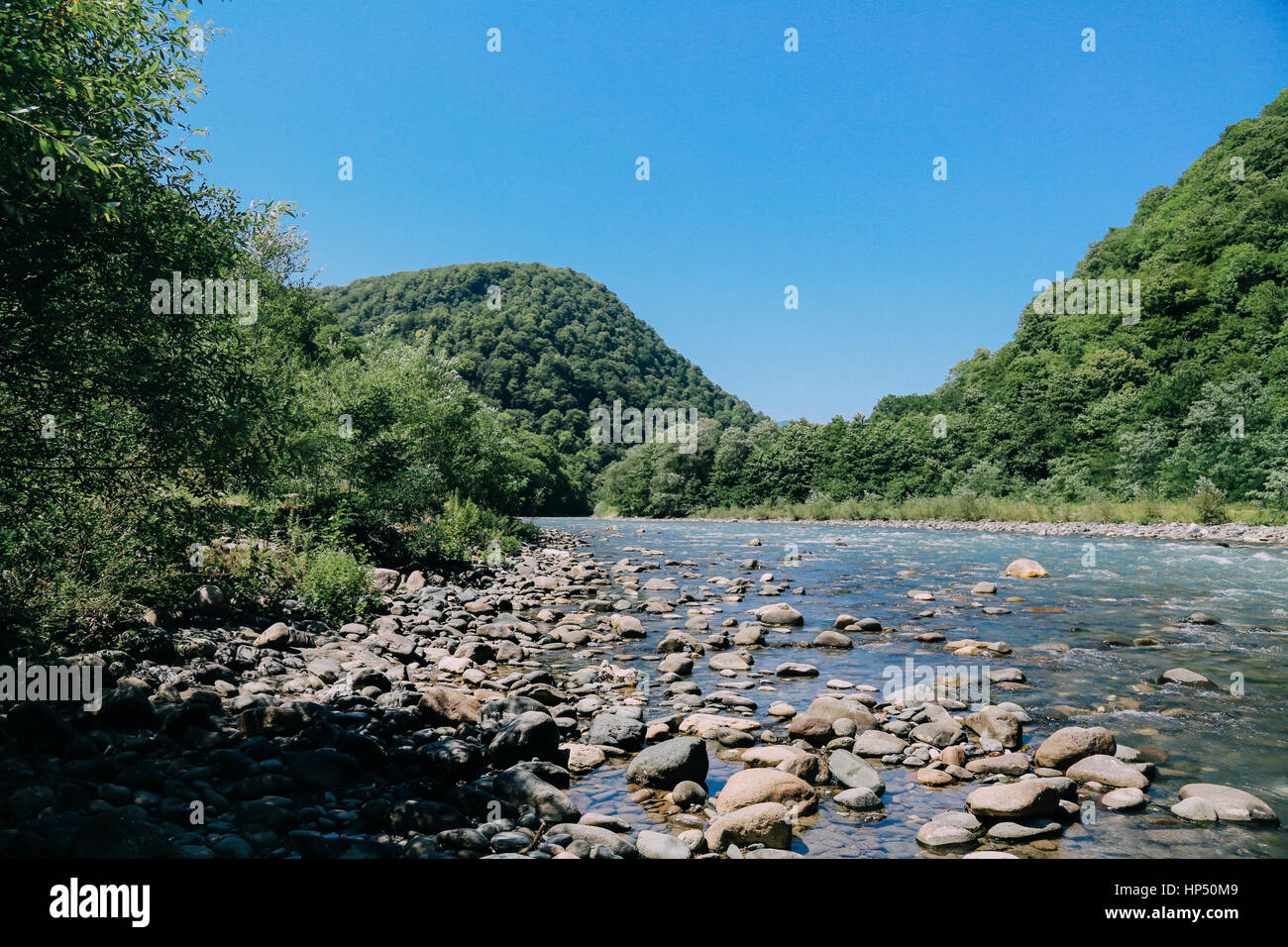 cold mountain river flowing past rocks Stock Photo