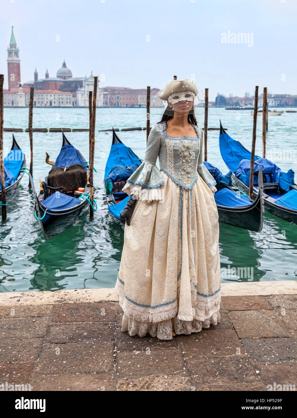 Venice, Italy- February 198th, 2012:A woman ina beautiful dress and  colombina mask posing in front of gondolas dock during the Venice Carnival  Stock Photo - Alamy