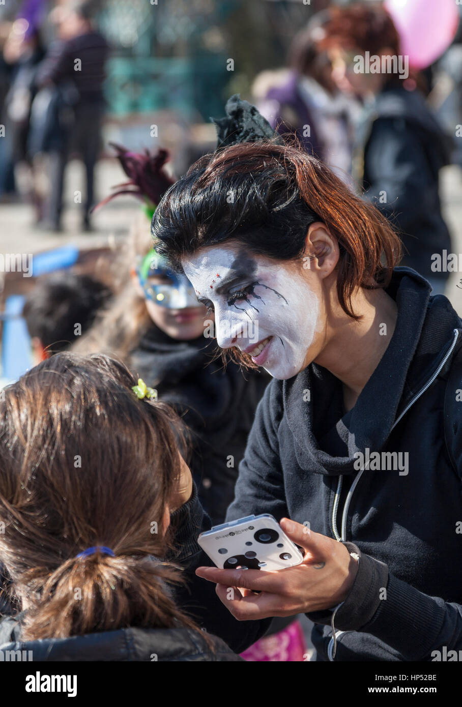 Venice,Italy-February 26, 2011: Environmental portrait of a female street face painter working on Sestiere Castello in Venice during the Venice carniv Stock Photo