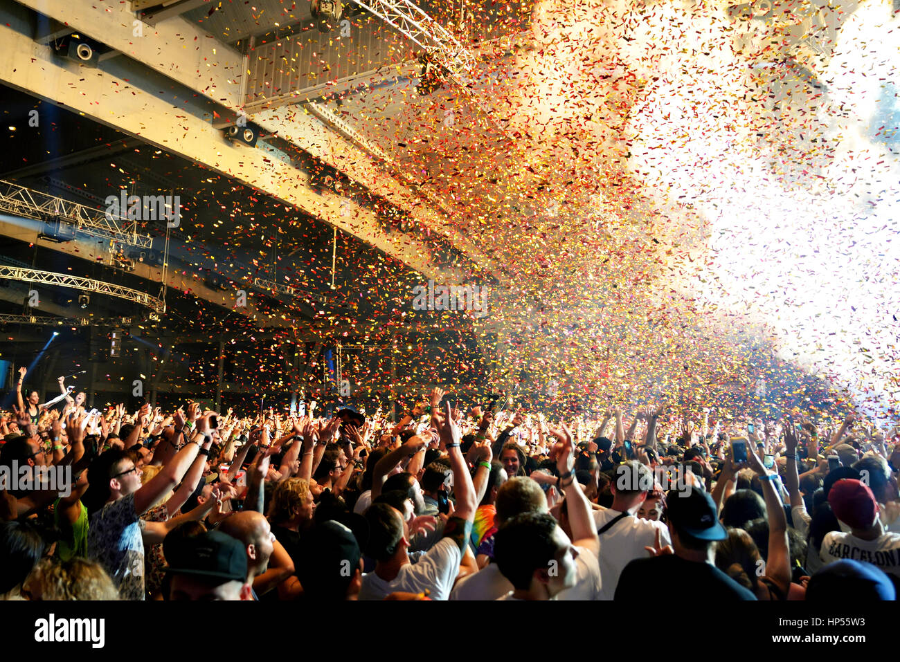 BARCELONA - JUN 19: Crowd in a concert, while throwing confetti from the stage at Sonar Festival on June 19, 2015 in Barcelona, Spain. Stock Photo