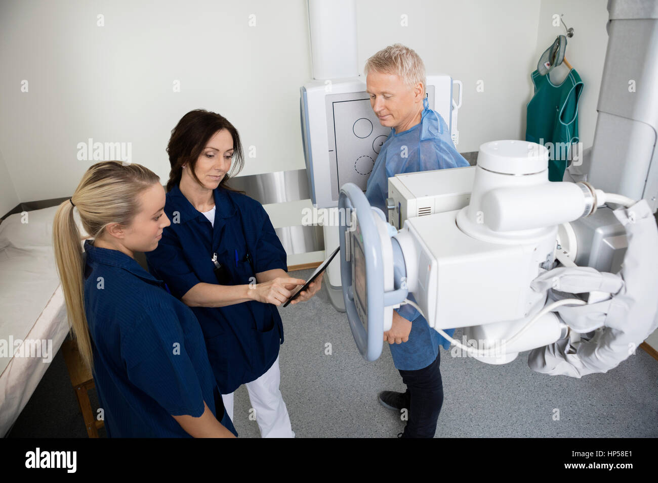 Patient Looking At Radiologists Using Digital Tablet In Hospital Stock Photo