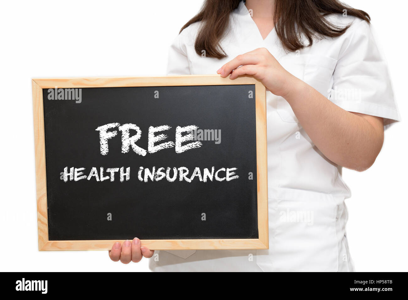 Female nurse holding a slate board with the text Free Health Insurance written with chalk, isolated on white background. Stock Photo