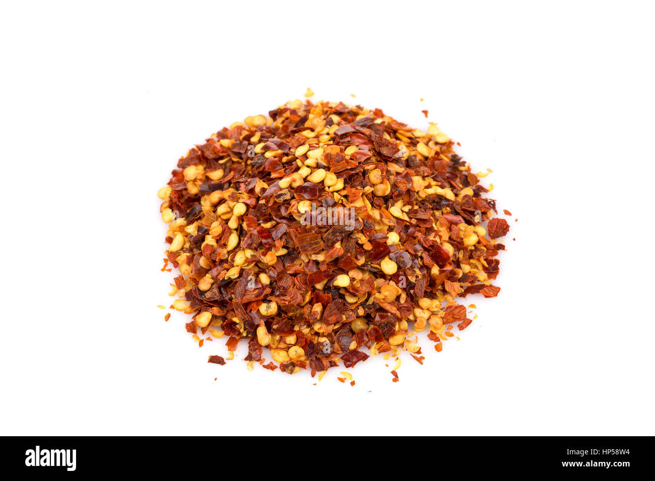 The pile of a crushed red pepper, dried chili flakes and seeds isolated