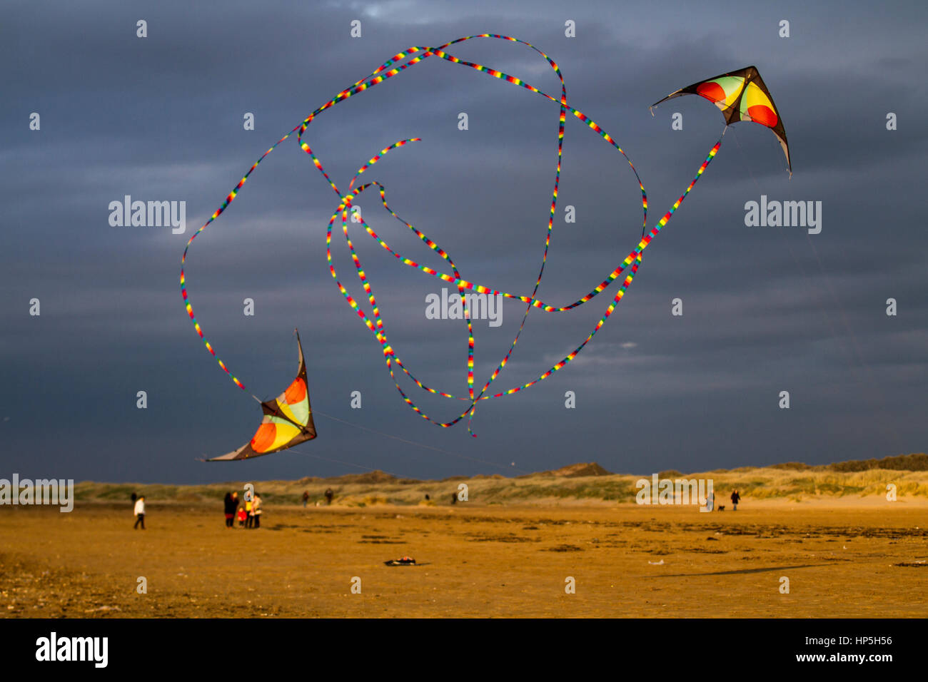 Paired Stunt kites with tails in Southport, Merseyside, UK.  Weather. February, 201. Precision Stunt Kites on Ainsdale Beach. Barmy temperatures in the resort bring holiday makers and day trippers to enjoy various activities on the extensive sands of the resort. Credit: MediaWorldImages/AlamyLiveNews. Stock Photo