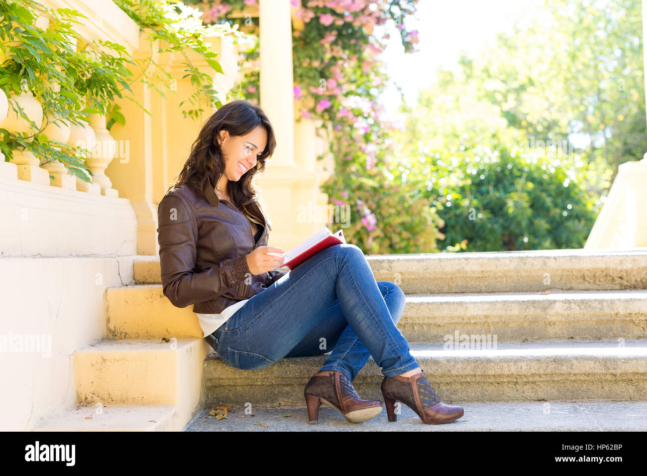 Young woman reading a book and relaxing at the park Stock Photo - Alamy