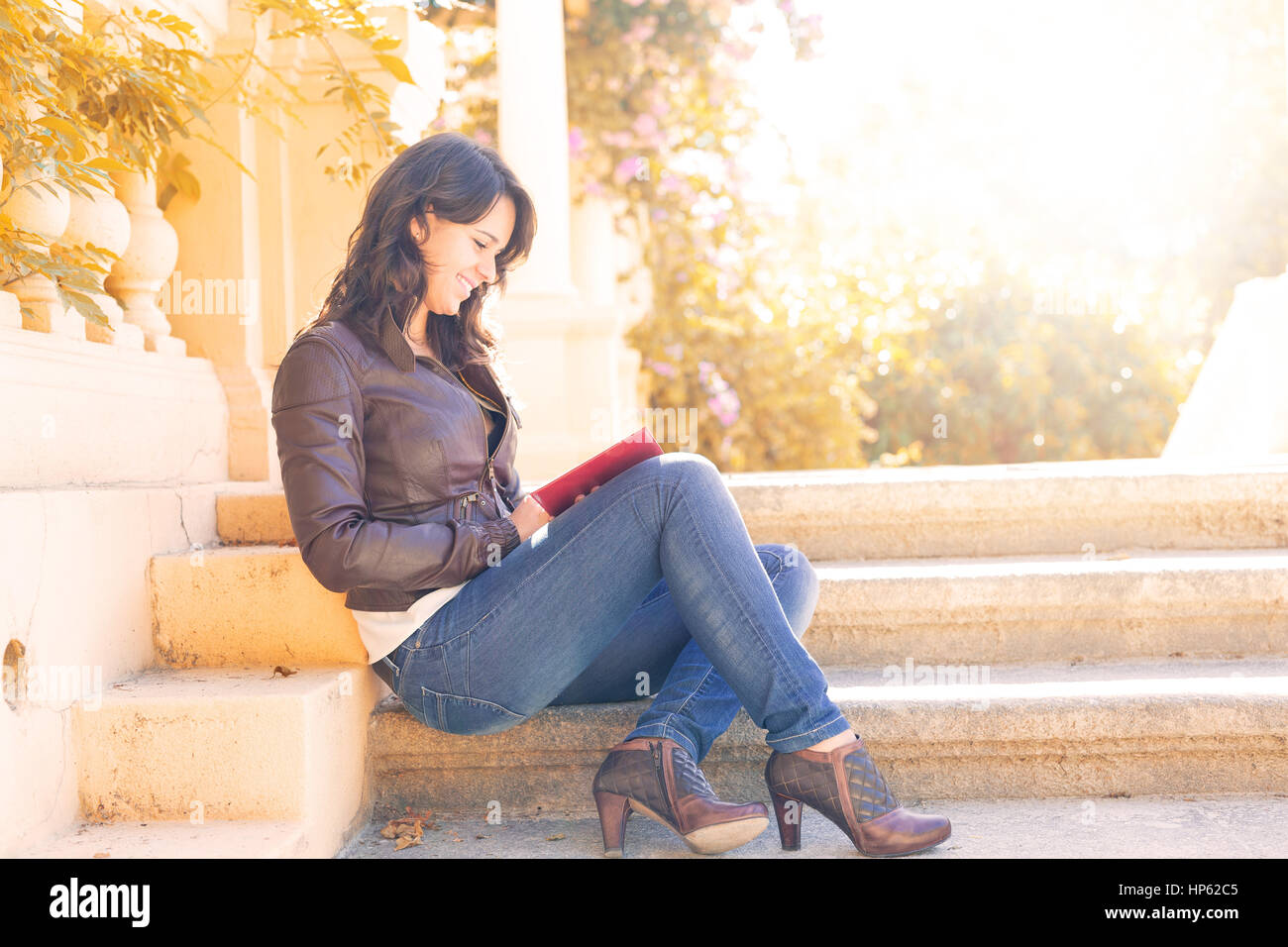Young woman reading a book and relaxing at the park Stock Photo - Alamy