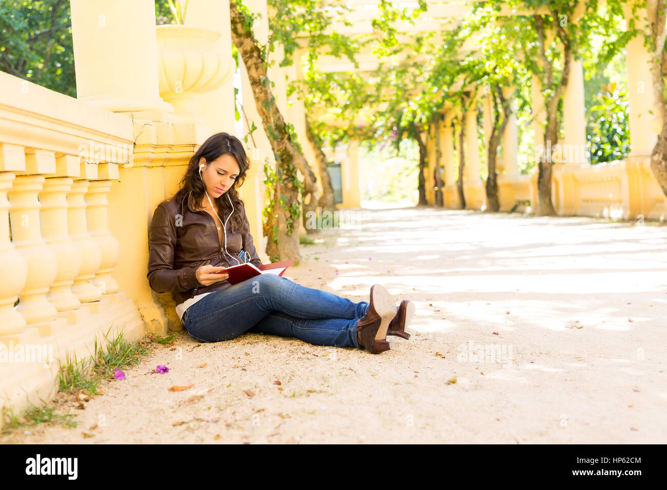 Young woman reading a book and relaxing at the park Stock Photo - Alamy