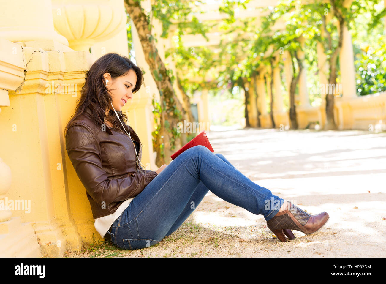Young woman reading a book and relaxing at the park Stock Photo - Alamy