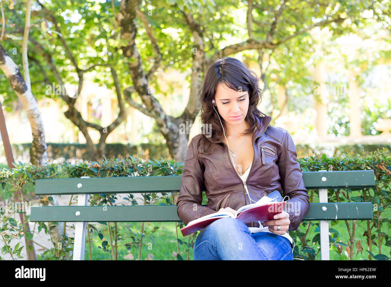 Young woman reading a book and relaxing at the park Stock Photo - Alamy