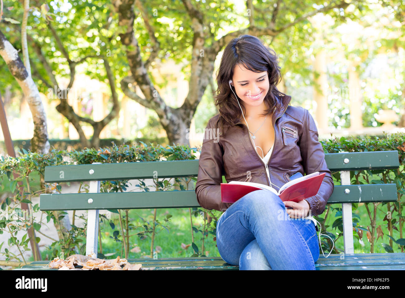 Young woman reading a book and relaxing at the park Stock Photo - Alamy
