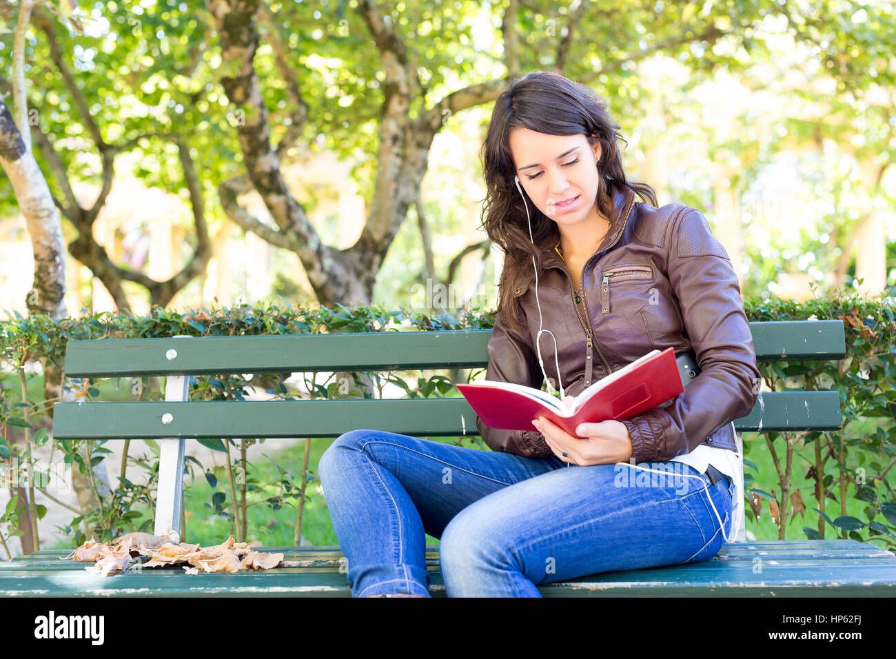 Young woman reading a book and relaxing at the park Stock Photo - Alamy