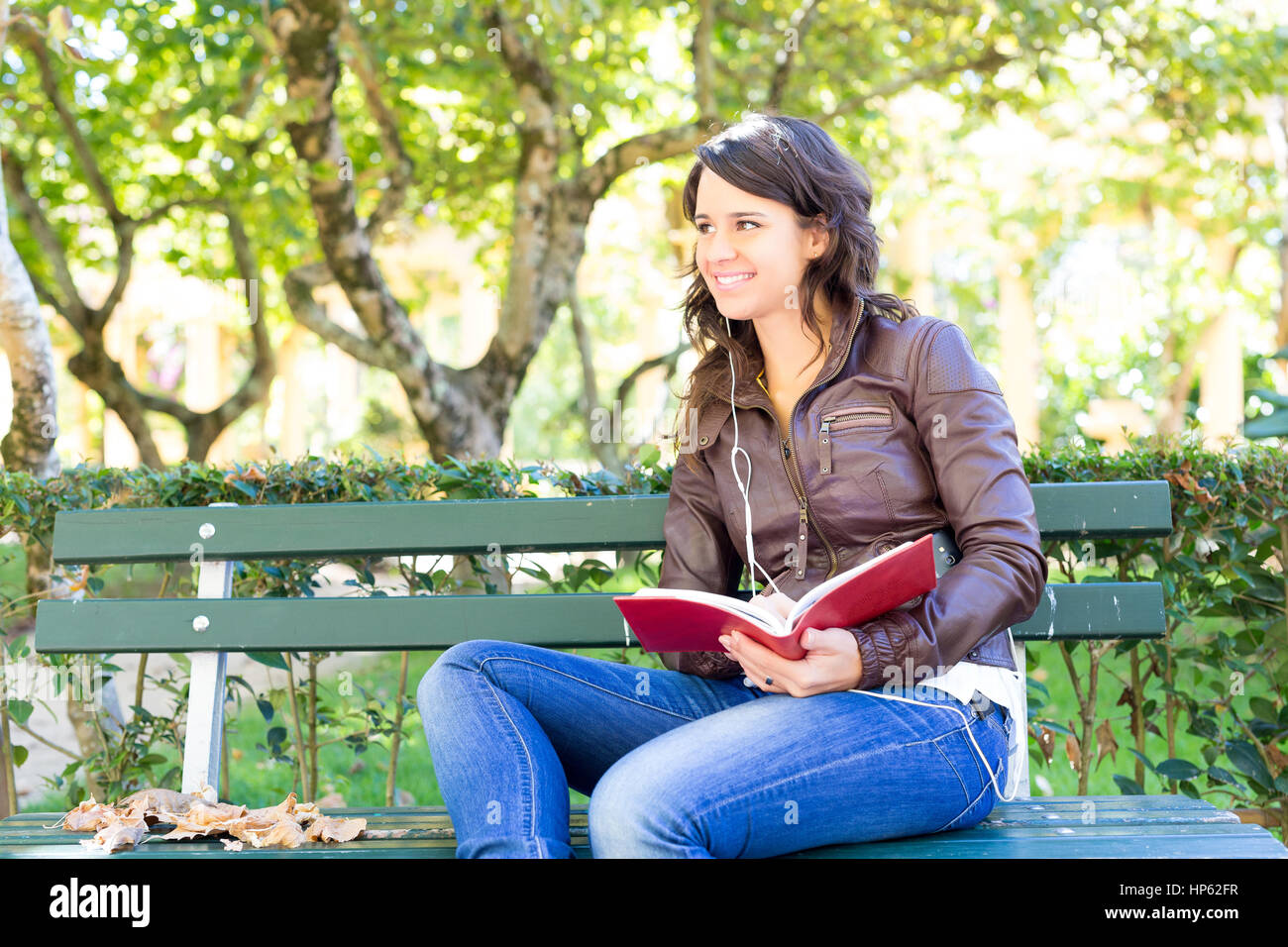 Young woman reading a book and relaxing at the park Stock Photo - Alamy