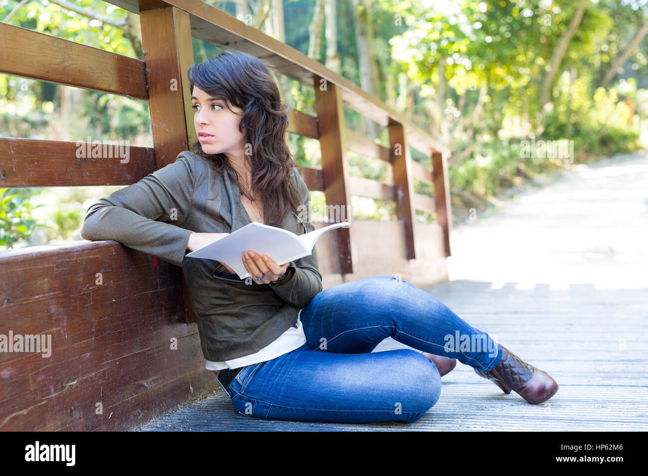 Young woman reading a book and relaxing at the park Stock Photo - Alamy