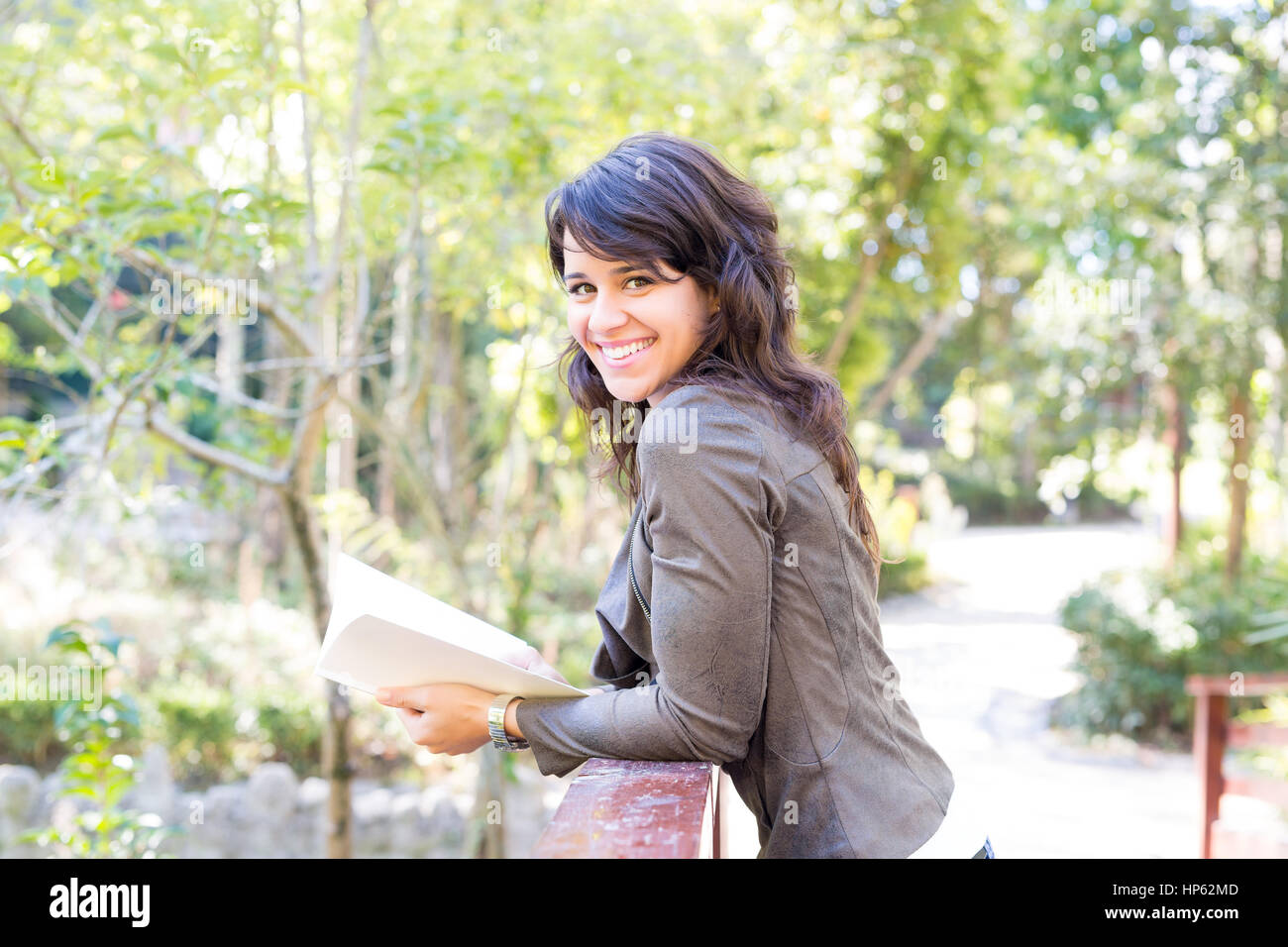 Young woman reading a book and relaxing at the park Stock Photo - Alamy