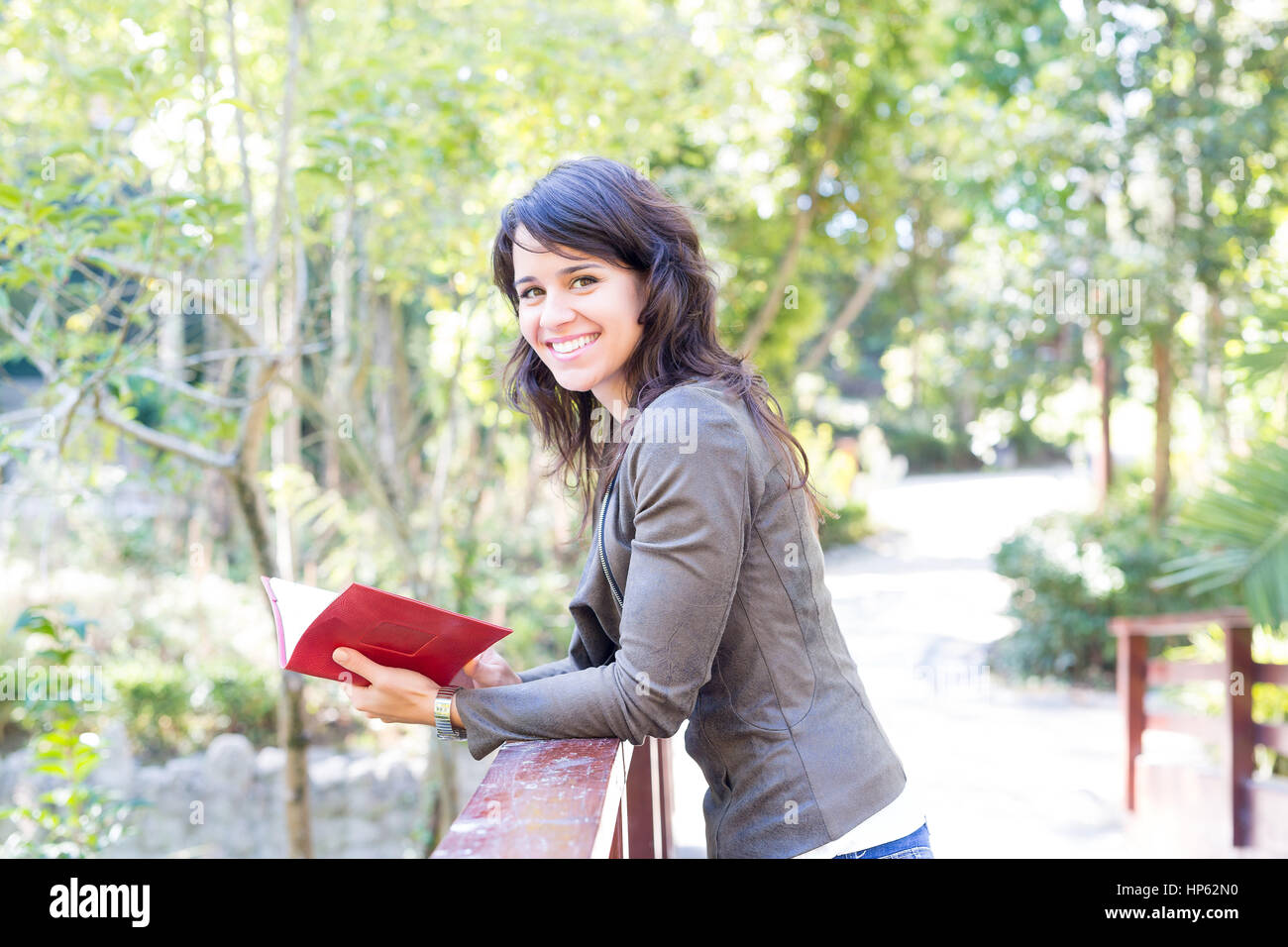 Young woman reading a book and relaxing at the park Stock Photo - Alamy