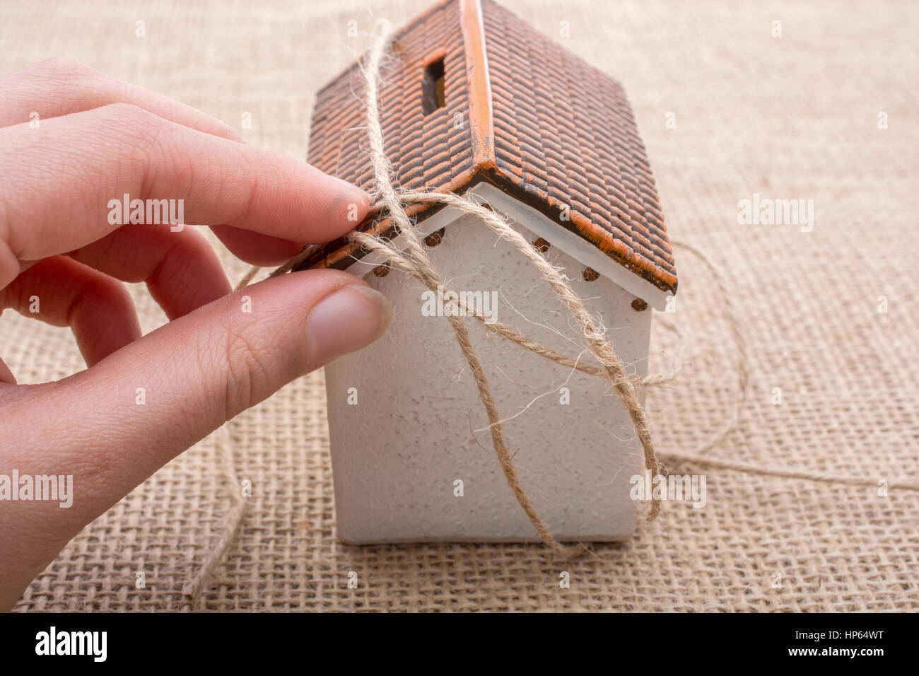 Thread wrapped around a model house on a brown background Stock Photo ...
