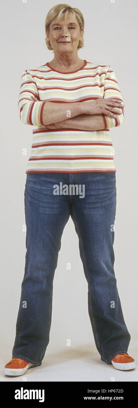 Seniorin in Jeans und Pulli, verschraenkte Arme (model-released) Stock Photo