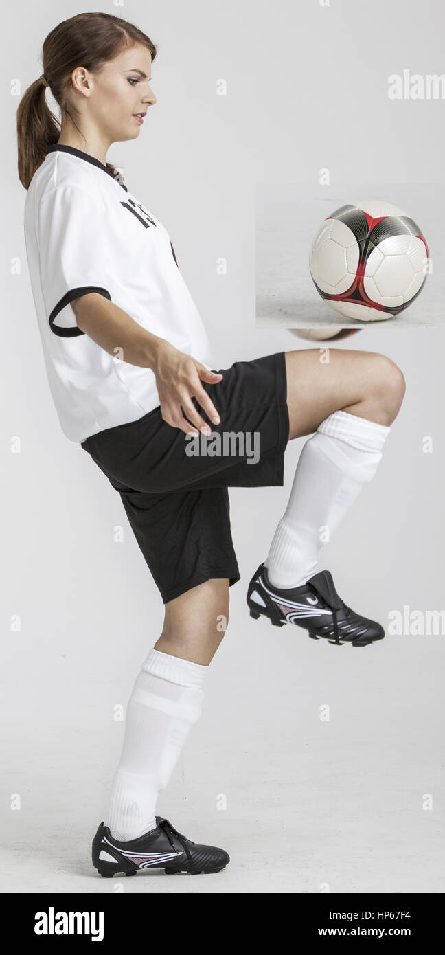 Fussballspielerin spielt Ball mit Knie (model-released ...