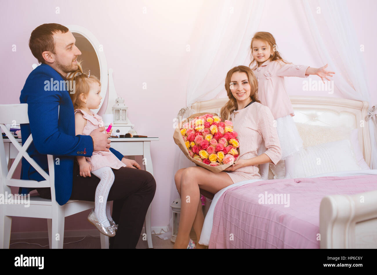 Young Loving Family Of Four People Portrait In Bedroom Stock