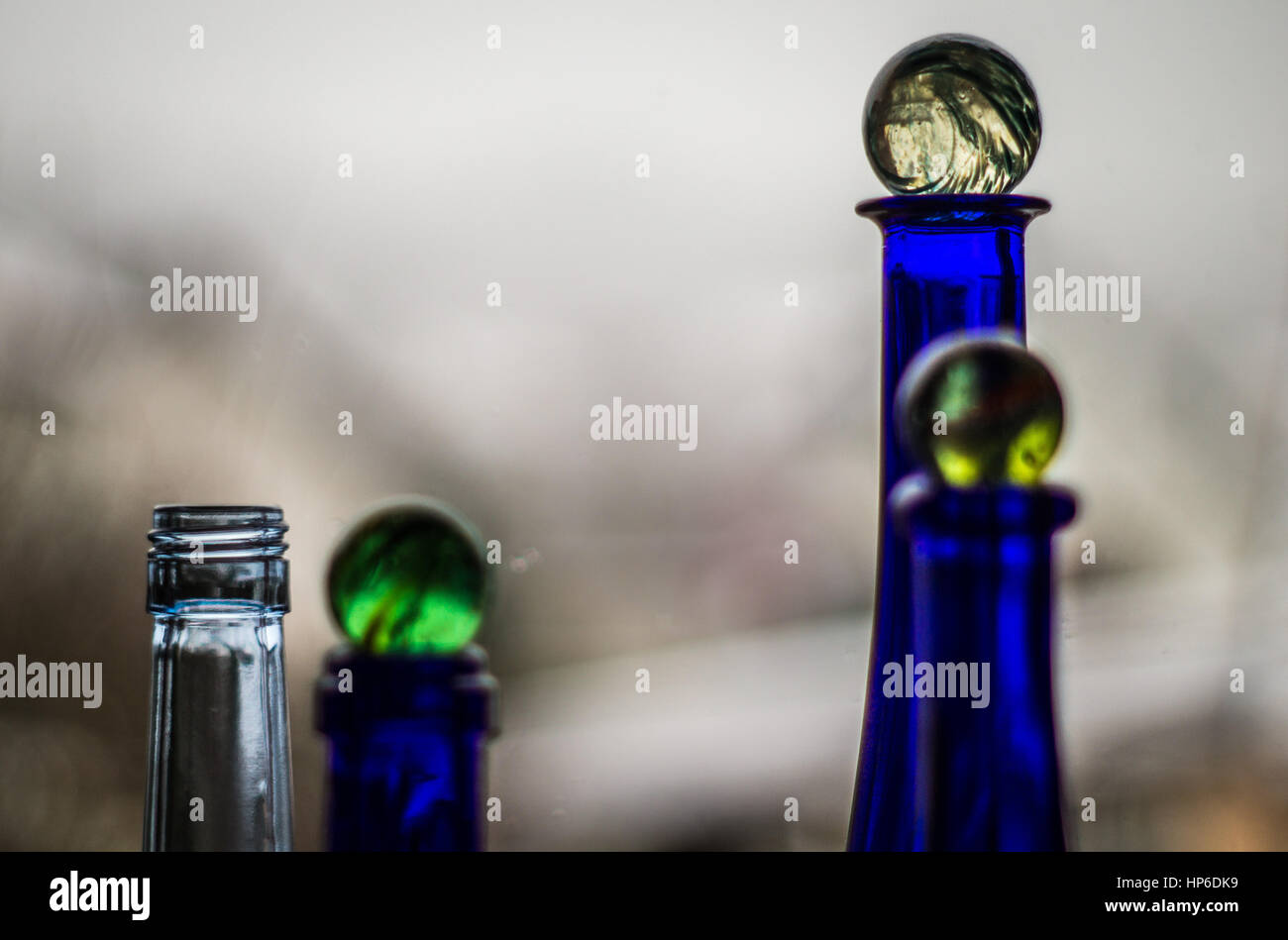 Green marbles on blue bottle Stock Photo