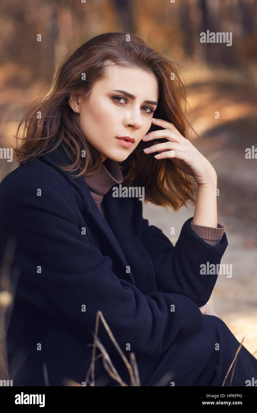 Fashion style portrait of young beautiful elegant woman in black coat ...