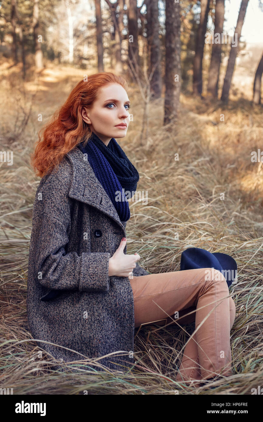 Beautiful red-haired woman. Redhead girl in autumn clothes in the forest.  Redhead woman outdoor in autumn park, weared scarf and coat. Autumn fashion  Stock Photo - Alamy