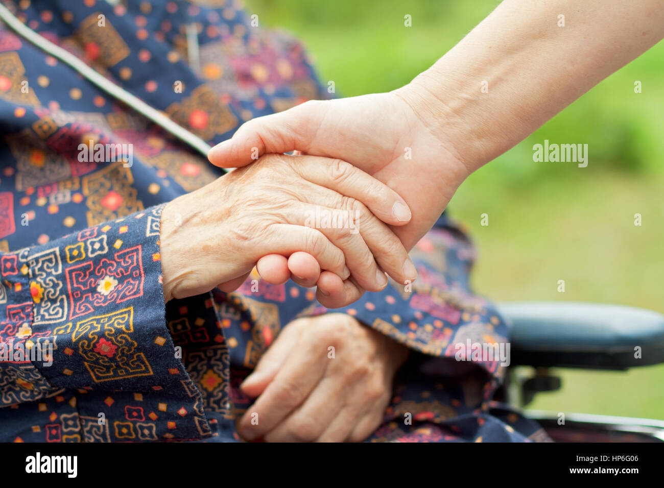 Doctor's hand holding a wrinkled elderly hand Stock Photo