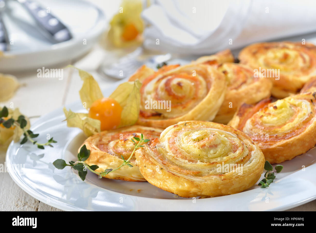 Baked hearty puff pastry rolls with smoked slamon, cream cheese and fesh herbs Stock Photo