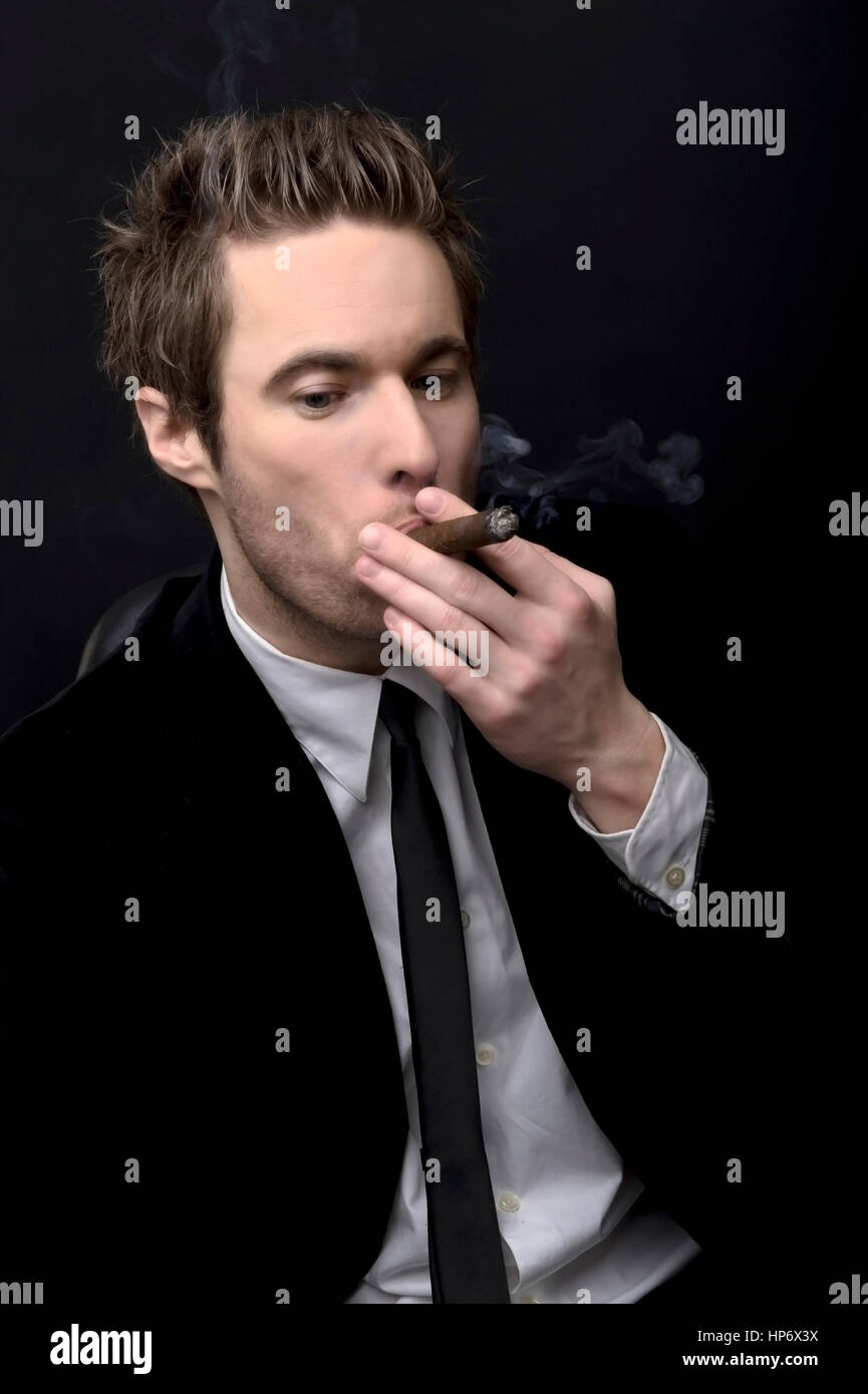Junger Mann in Anzug und Krawatte raucht Zigarre - man smoking cigar Stock  Photo - Alamy