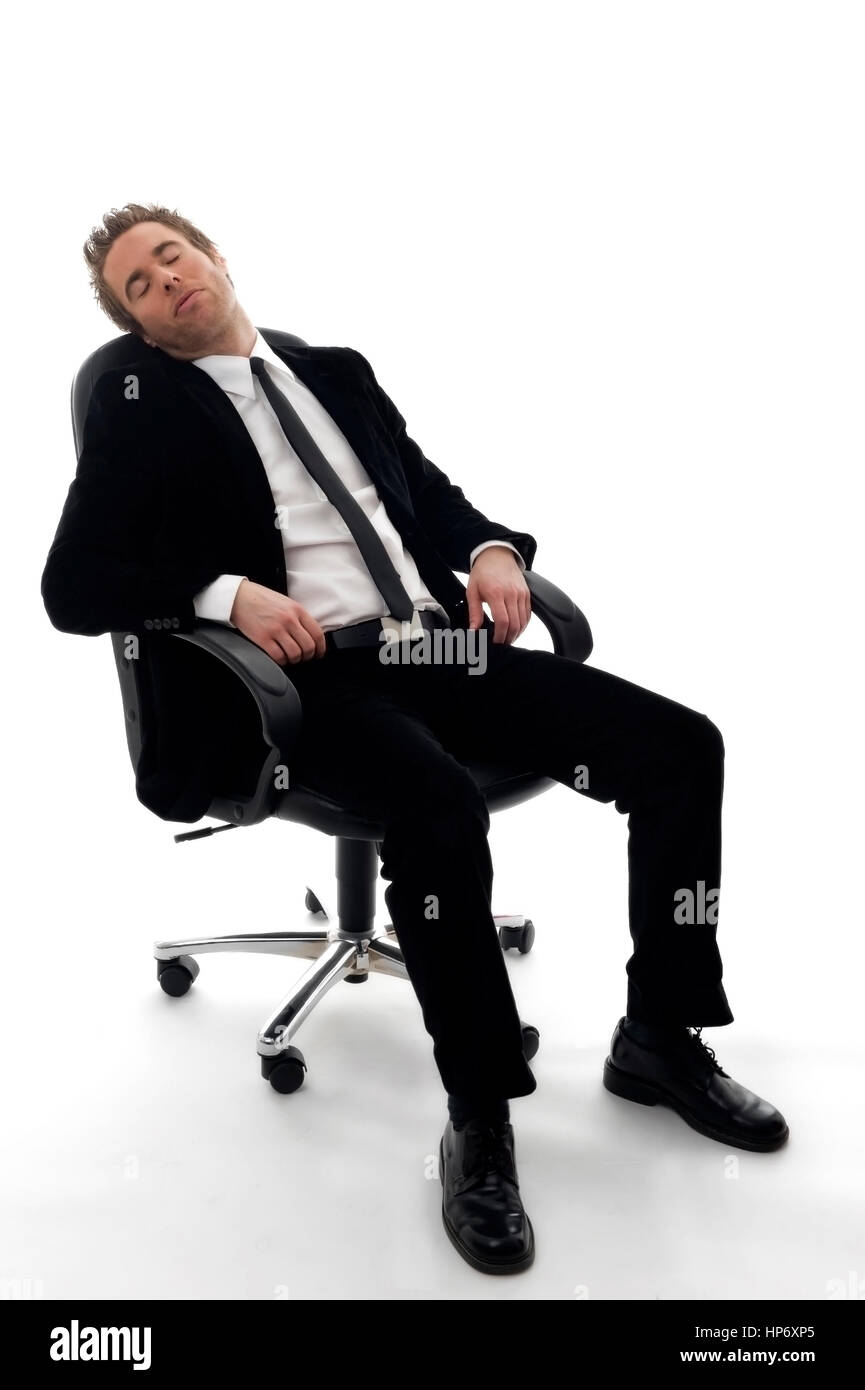 Junger Geschaeftsmann sitzt am Buerostuhl und schlaeft - businessman sleeping Stock Photo