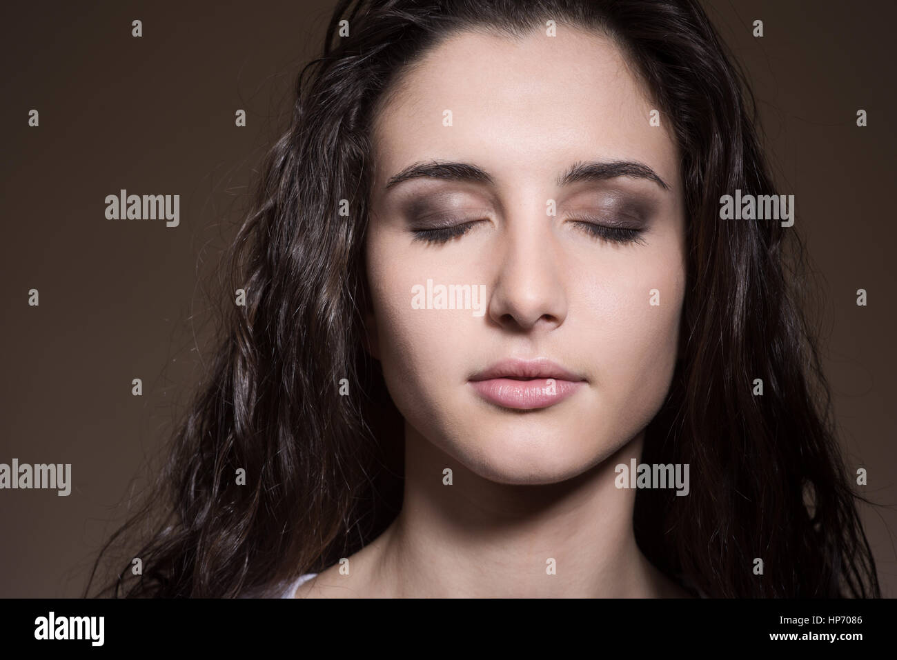 Relaxed woman posing with closed eyes on dark background Stock Photo ...