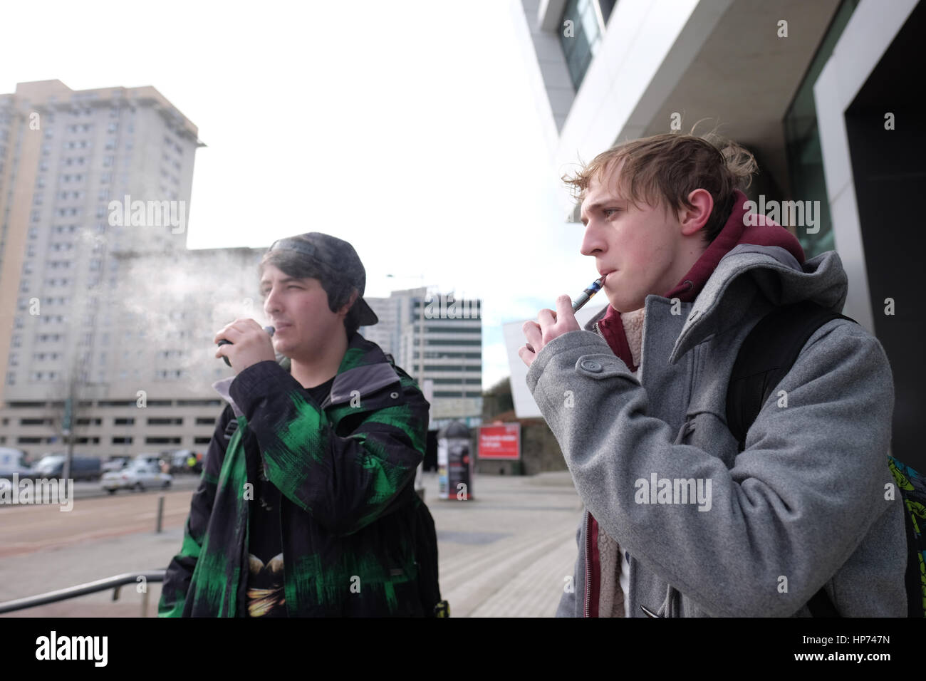 Carrie Edwards (left) 22 of age and Andrew Shaw (right) (22), USW Music Industry students, smoke e-cigarette during a break outside Atrium USW Stock Photo