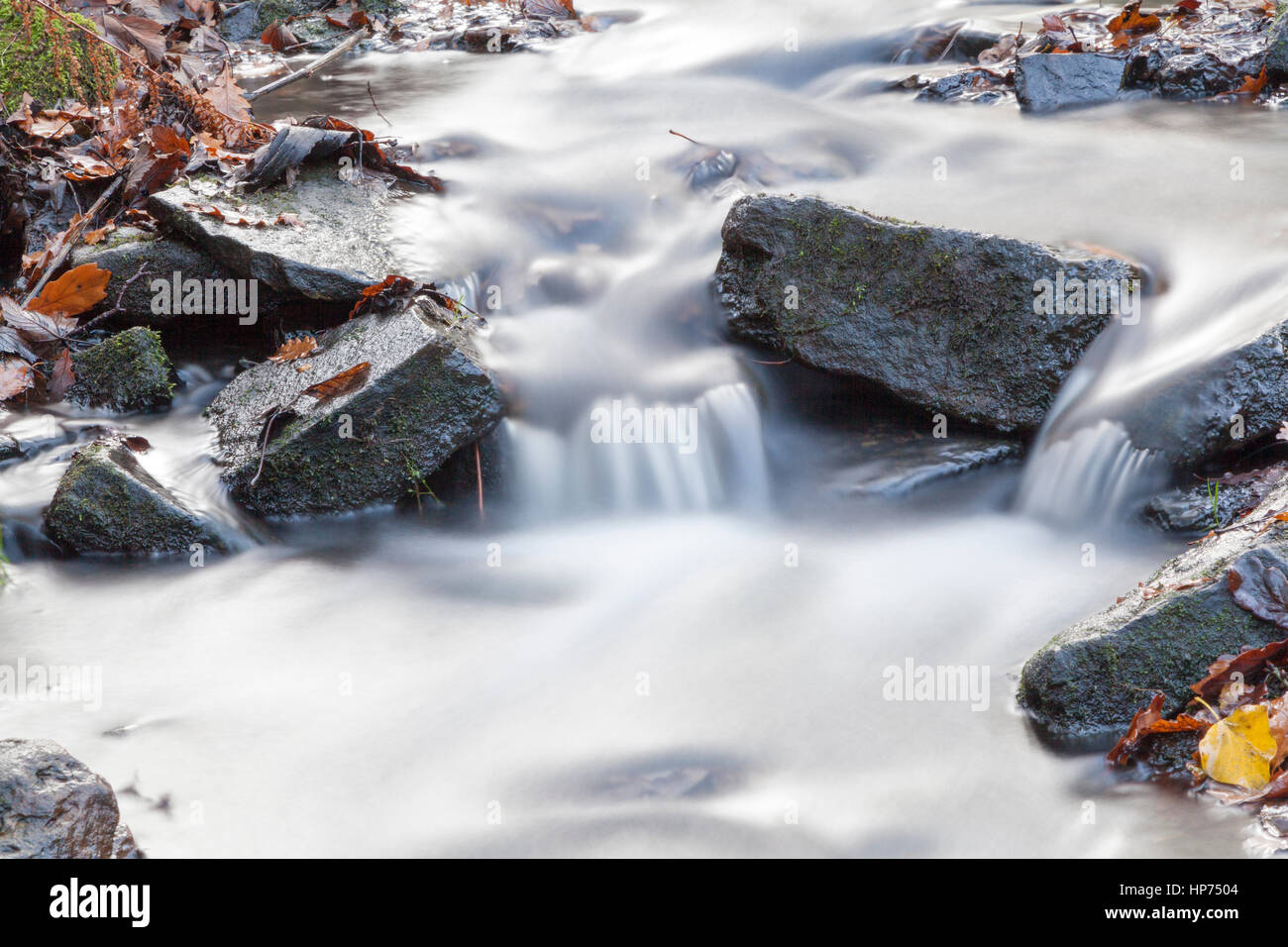Blurred motion of river water over rocks. Stock Photo