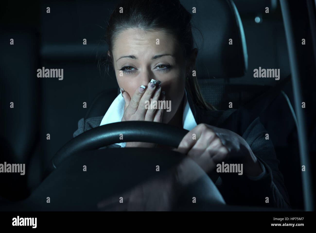 Distracted exhausted woman driving a car late at night Stock Photo Alamy