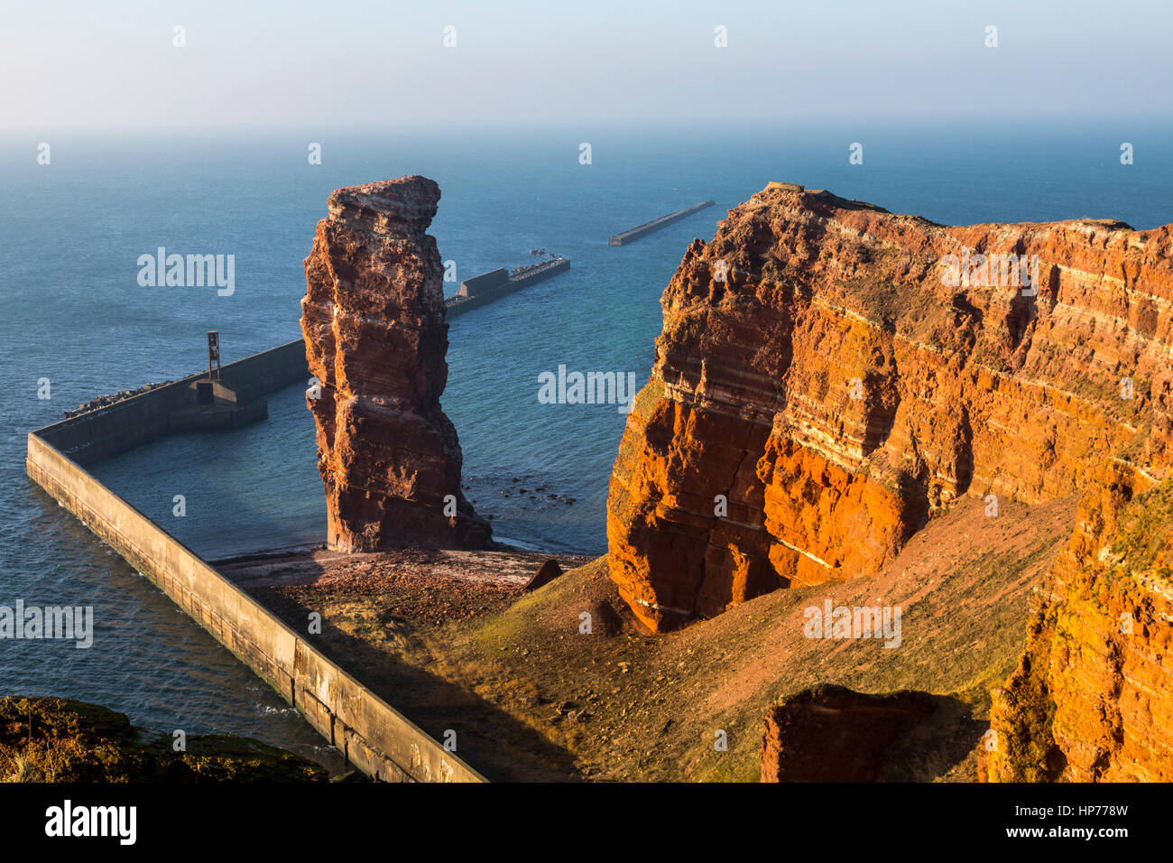 The red steep coast line of Helgoland, an German Island in the North Sea,  rock needle called Lange Anna, the landmark of the island Stock Photo -  Alamy