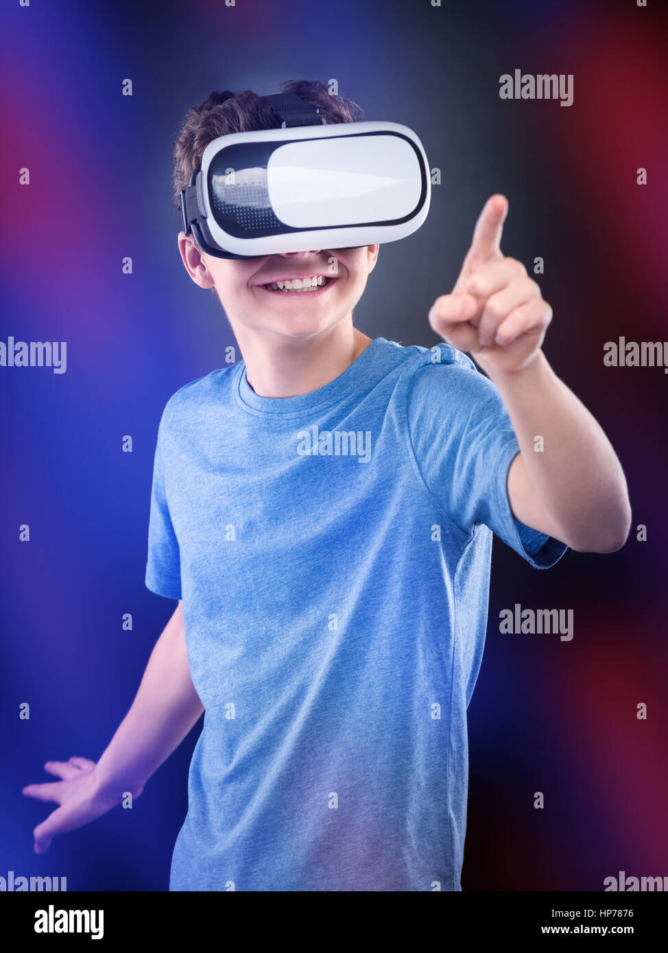 Happy teen boy wearing virtual reality goggles playing video games, on