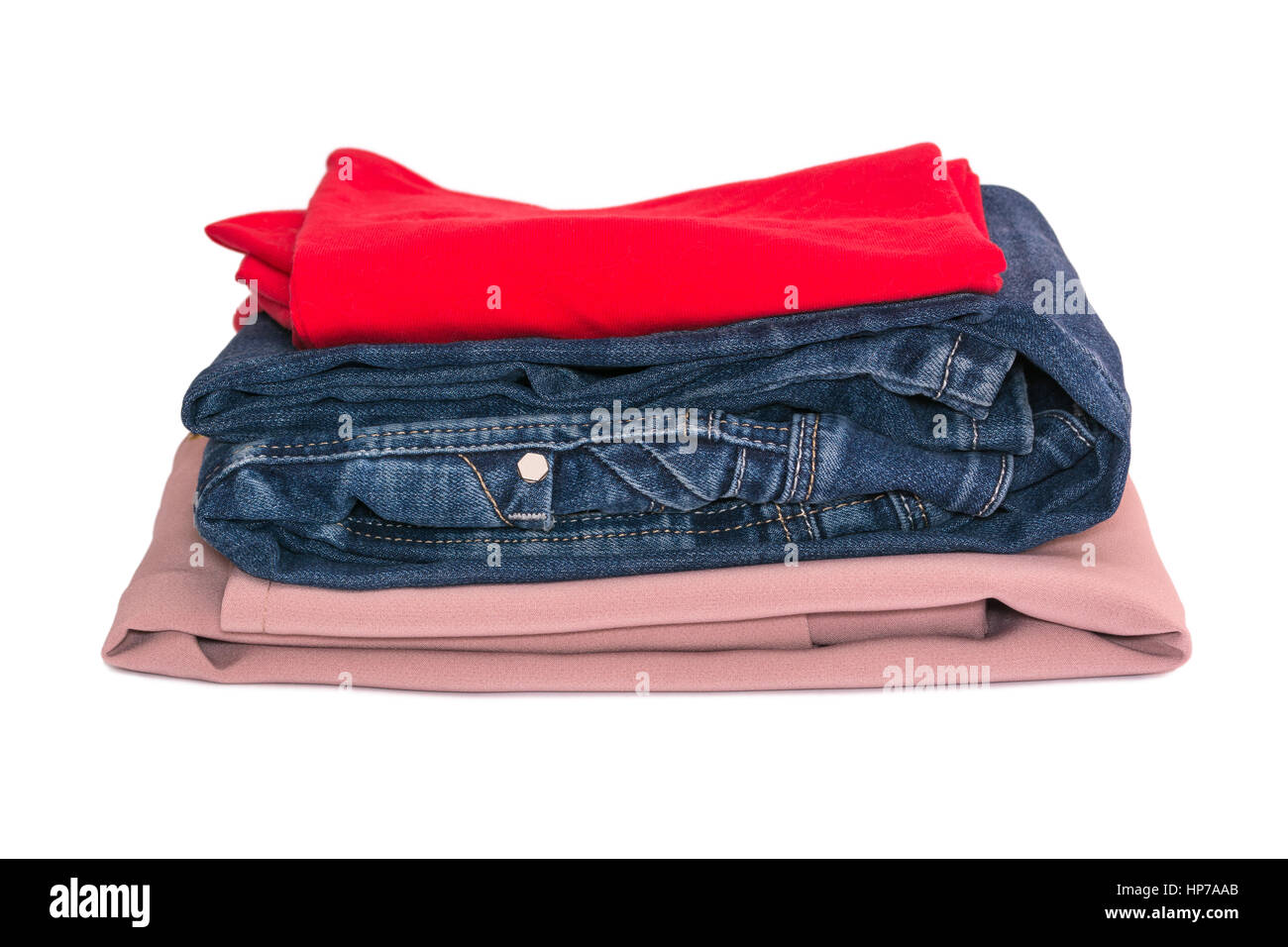 Stack of clothes isolated on white background. Jeans, red and beige blouse Stock Photo