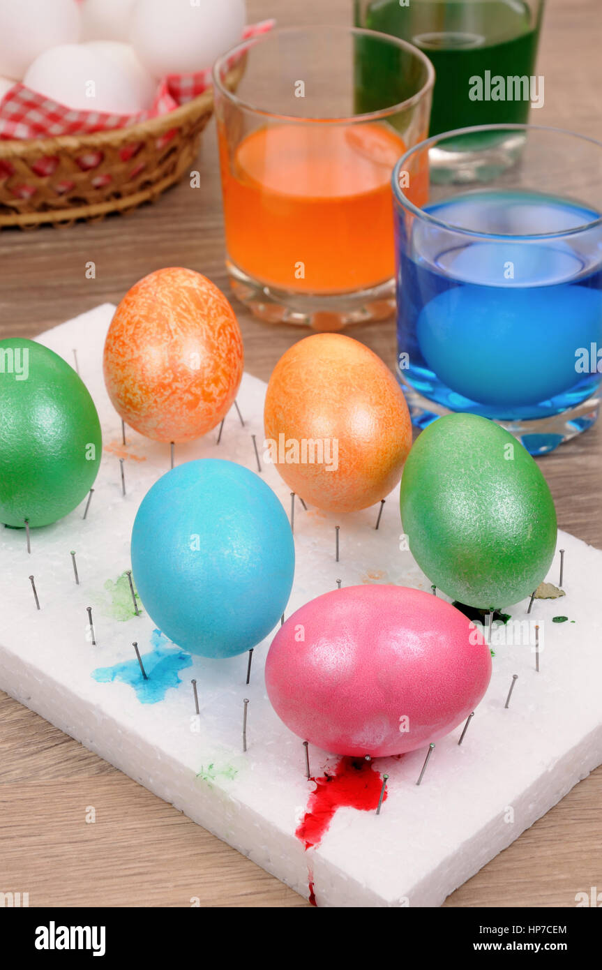 Preparing for the holiday Easter. The process of painting eggs with food coloring Stock Photo