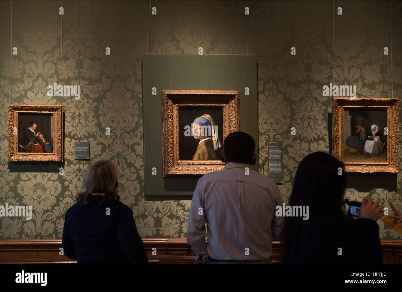 Visitors admiring and photographing Johannes Vermeer, Girl with a Pearl Earring (Meisje met de parel) 1665  - Mauritshuis Museum The Hague Stock Photo